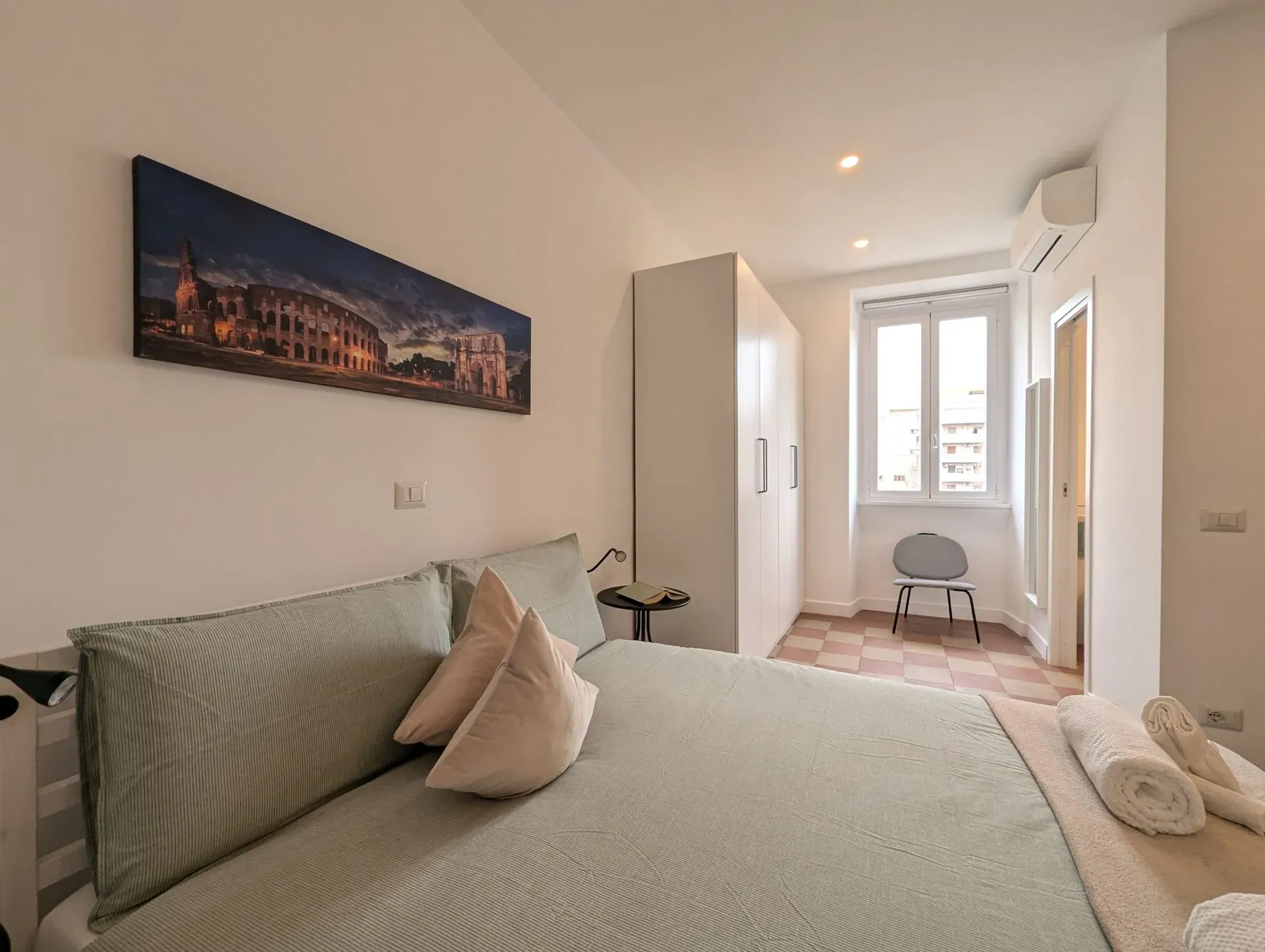 Camera matrimoniale con armadio, aria condizionata e quadro del Colosseo