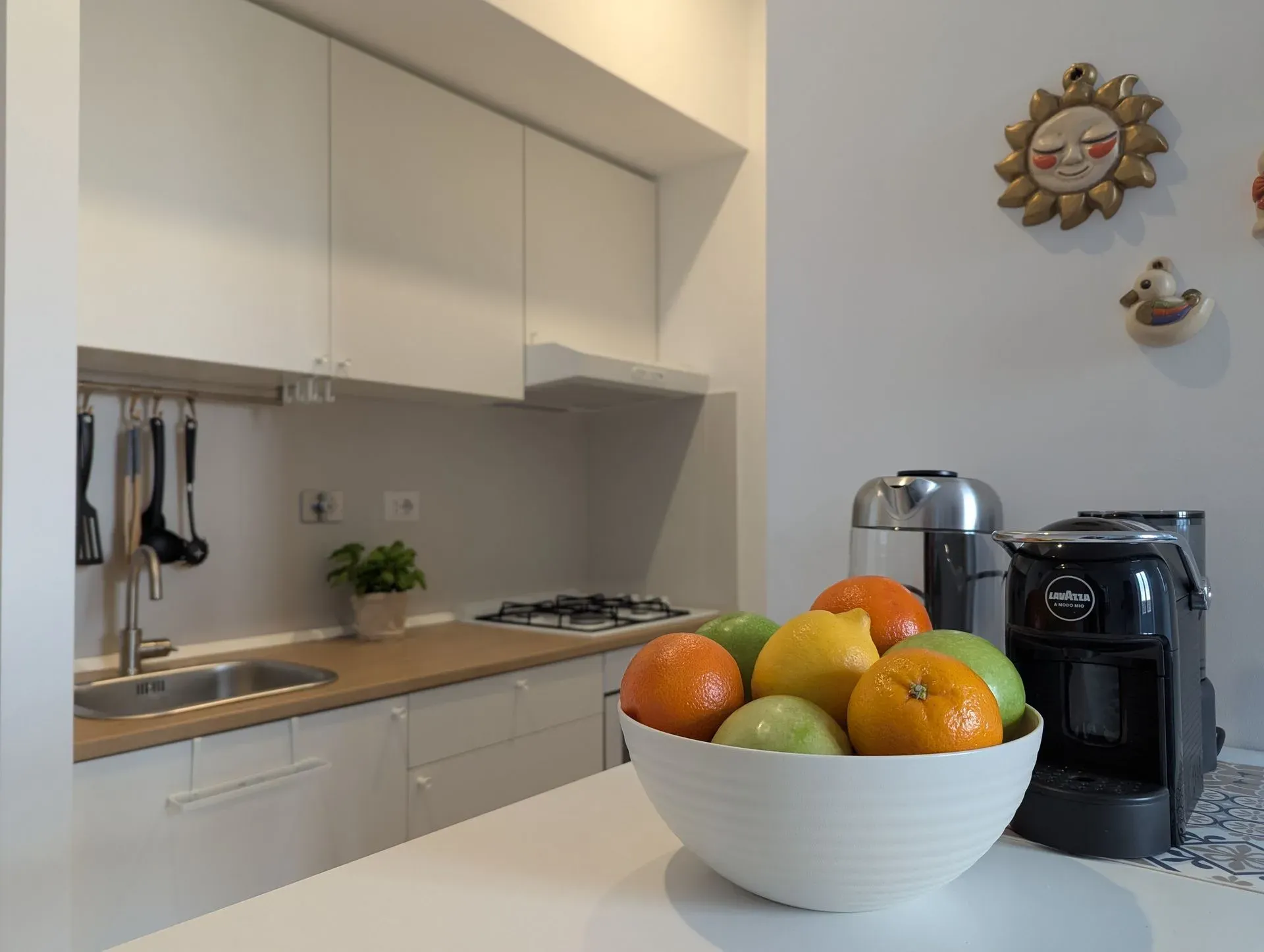 Angolo cucina con macchine del caffè e cesto di frutta