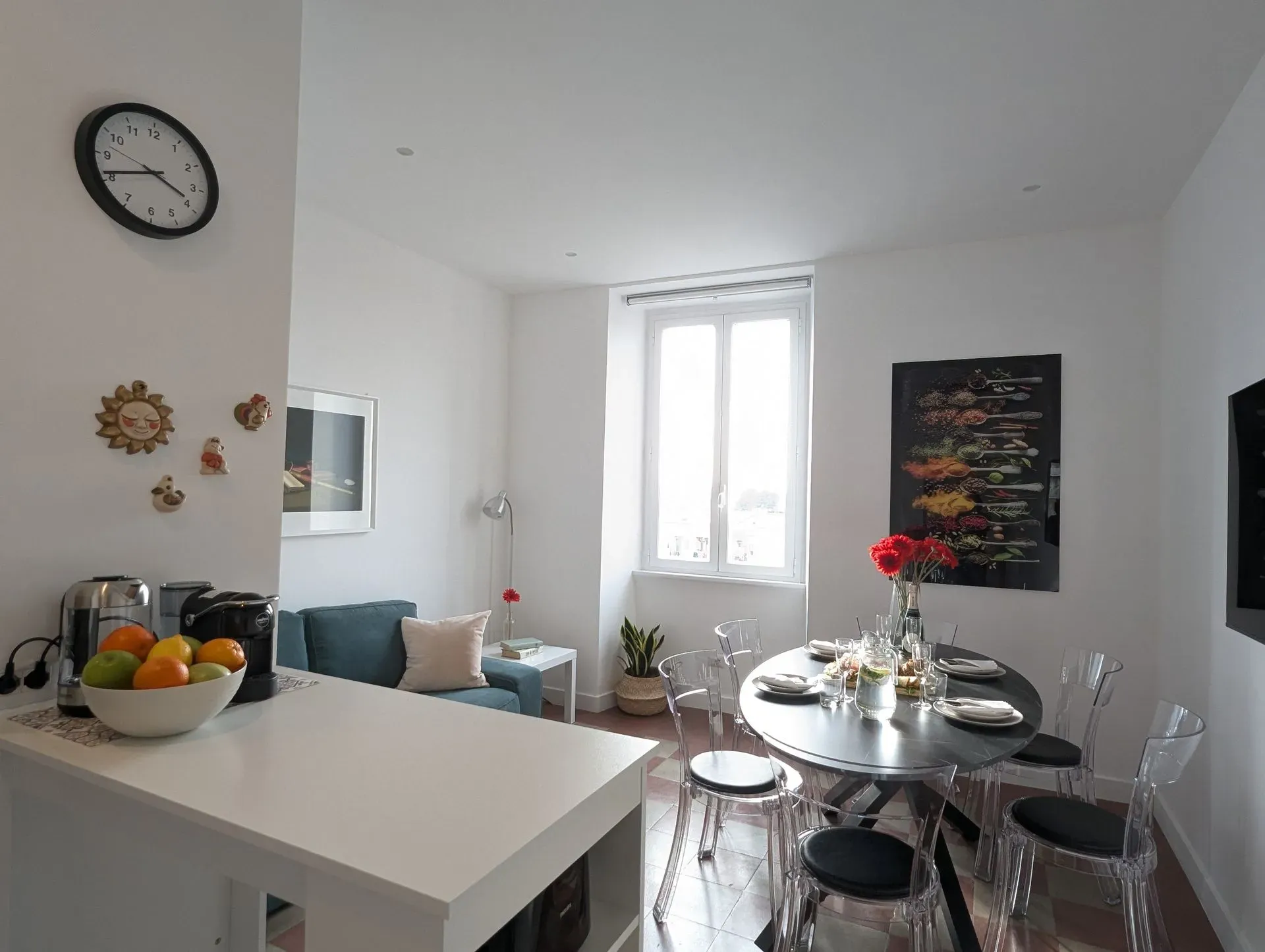 Zona giorno aperta tra cucina, divano e tavolo